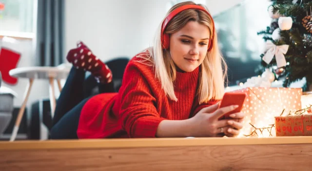 Chica-escuchando-musica-tumbada-al-lado-del-arbol-de-navidad-Girl-listening-to-music-lying-next-to-Christmas-tree